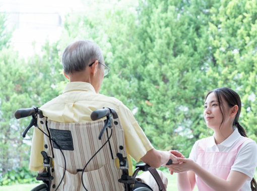 看護師と車いすの高齢男性